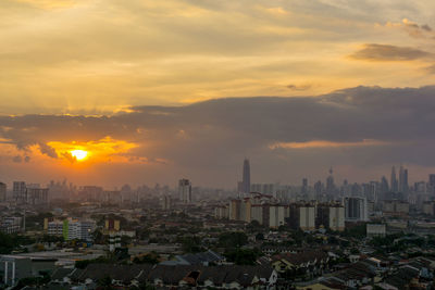 View of cityscape against cloudy sky during sunset