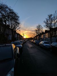 Cars on road against sky during sunset