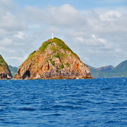 Rock formation in sea against sky