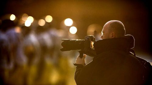 Man holding illuminated lighting equipment at night