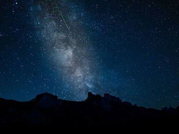 Silhouette mountains against sky at night