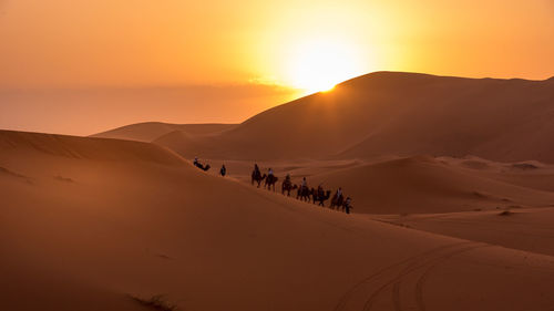 Scenic view of desert against sky during sunset