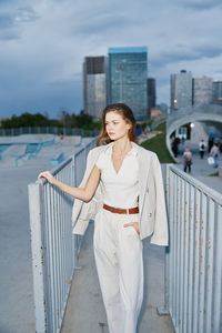 Portrait of young woman standing in city