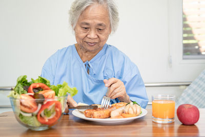 Portrait of senior man having food at home