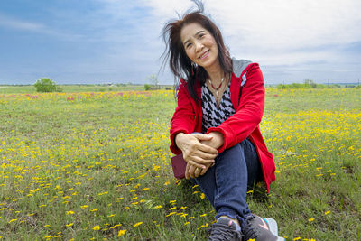 Beautiful young woman smiling while standing on field