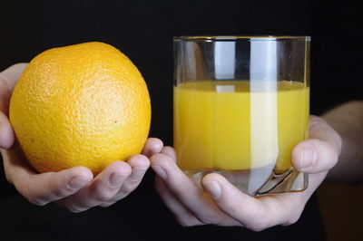 Close-up of hand holding glass of juice