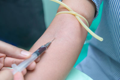 Cropped hand of doctor injecting patient