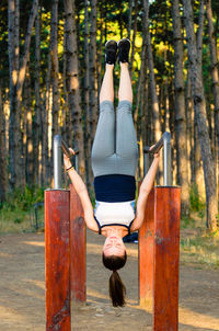 Full length of woman with arms raised in forest