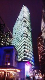 Low angle view of illuminated buildings against sky at night