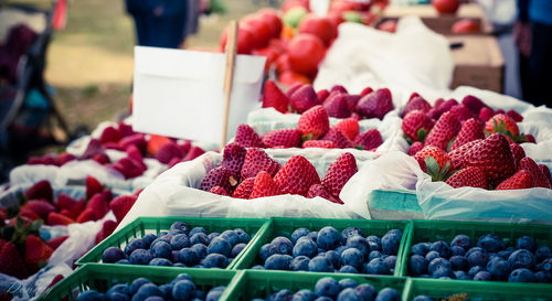 Strawberries and blueberries for sale at market stall