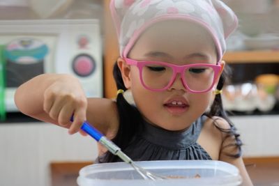 Close-up of cute girl preparing food on table