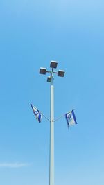 Low angle view of floodlight against blue sky