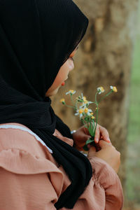 Midsection of woman holding bouquet