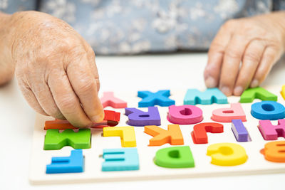 Cropped hands of man playing with toy blocks on table