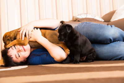Portrait of young woman with dog relaxing at home