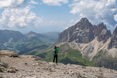 Rear view of man walking on mountain against sky
