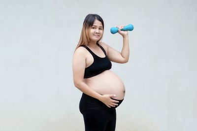 Full length of woman standing against white background