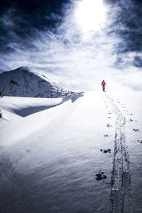 Person skiing on snowcapped mountain against sky