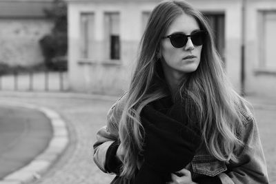 Young woman wearing sunglasses standing in city