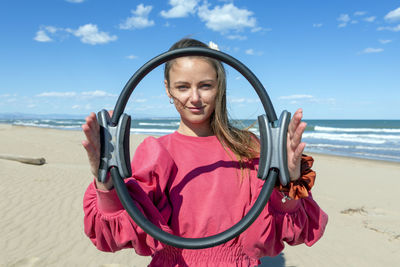 Portrait of man with arms raised at beach