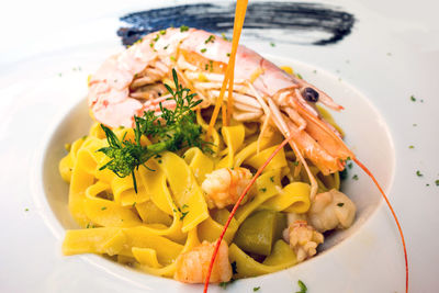 Close-up of pasta with shrimps served in white plate