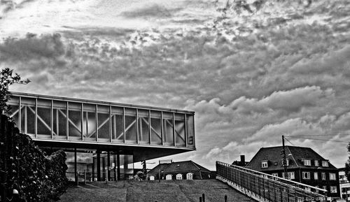 Low angle view of bridge against cloudy sky