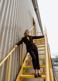 Portrait of young woman standing on steps