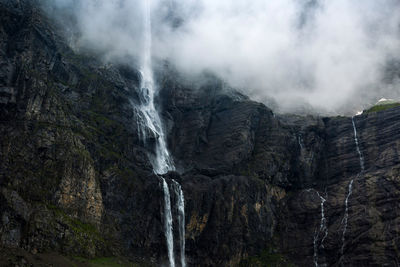 Thin stream of clean water flowing on rough mountain slope in cirque de gavarnie in pyrenees