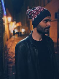 Young man looking away outdoors at night