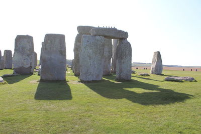 Stone structure on field against clear sky