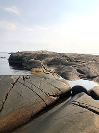 Rocks by sea against sky