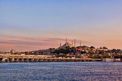 Bridge by sea against historic mosque in city