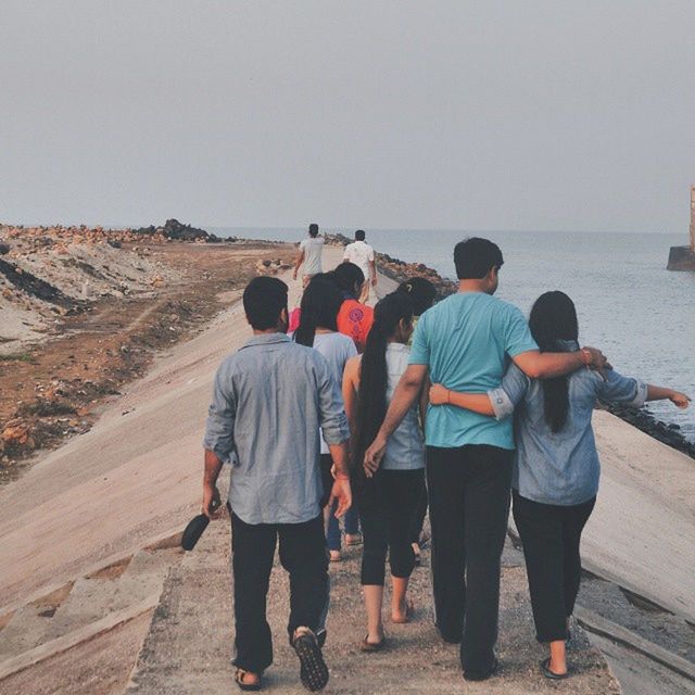 togetherness, rear view, lifestyles, men, clear sky, bonding, leisure activity, full length, sea, person, beach, friendship, walking, love, casual clothing, water, standing, copy space