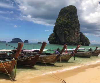 Deck chairs on beach against sky