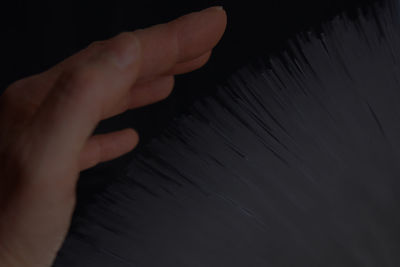 Close-up of human hand against black background