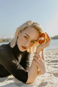 Portrait of young woman lying on beach