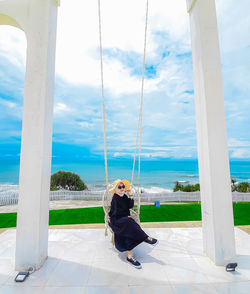 Rear view of woman sitting on swinging