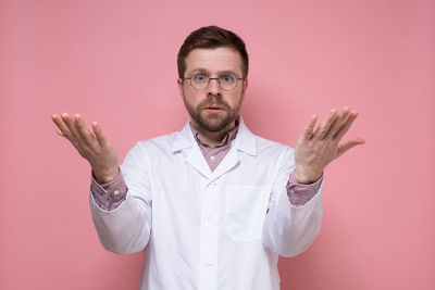 Portrait of man standing against colored background
