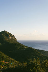 Scenic view of sea and mountains against sky