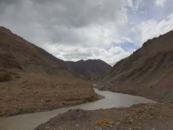 Scenic view of road by mountains against sky