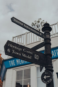 Low angle view of sign against sky in city