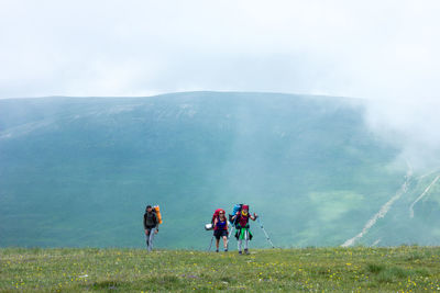 People on mountain road against sky