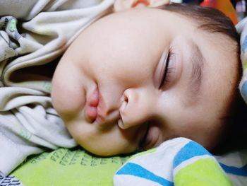 Portrait of cute baby sleeping on bed