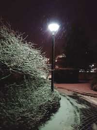 Illuminated street light against sky at night during winter