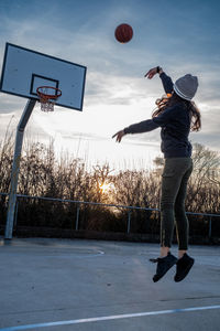 Full length of woman playing basketball