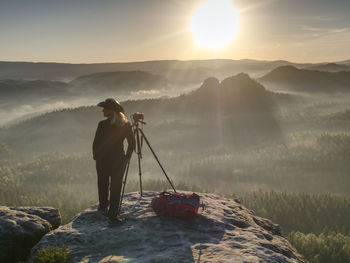 Nice girl photographer in cowboy cap photographing on her digital mirror camera. journey landscape