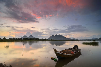 Scenic view of boat on calm lake with mountains in background