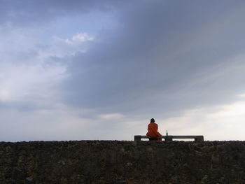 Rear view of man sitting on bench