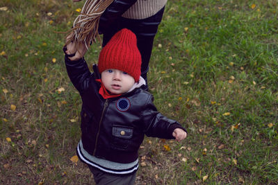 Mom and son in leather jackets walking on the field with dry grass autumn