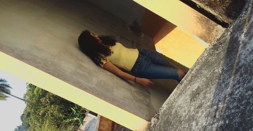 High angle view of woman relaxing on wall